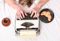 Old typewriter on bedclothes. Male hands type story or report using vintage typewriter equipment. Writing routine. No Royalty Free Stock Photo