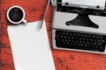 Old typewriter, cup of steaming hot coffee and stack of blank writing paper on table Royalty Free Stock Photo