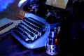 Old typewriter on desk, telephone, mystery detective concept, writer`s work tools, blue backlight Royalty Free Stock Photo