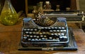 The Old typewriter on a dusty table with bottles Royalty Free Stock Photo