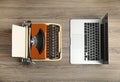 Old typewriter and laptop on wooden table, flat lay. Concept of technology progress Royalty Free Stock Photo