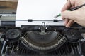 Old typewriter from seventies with paper and copy space. With writing hand