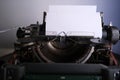 Old typewriter on table, blank white sheet for text, mockup, retro style, concept of works of a writer, journalist Royalty Free Stock Photo