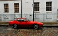 Old typical block of flats in Shoreditch London with red vintage car