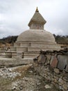 Old typical white Buddhist stupa in Himalaya mountains in cloudy weather Royalty Free Stock Photo