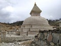 Old typical white Buddhist stupa in Himalaya mountains in cloudy weather Royalty Free Stock Photo