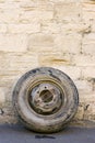 An old tyre leaning against a wall by the roadside