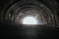 Old underground road tunnel inside mountain. Light at the end of tunnel Royalty Free Stock Photo