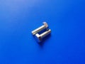 An old, unused bolts, silver in color on a blue background Royalty Free Stock Photo