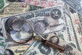 Old US banknotes and silver certificates with silver dollar coins and magnifying glass Royalty Free Stock Photo