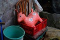 old used abandoned red reindeer plastic doll on a red seedling tray in the backyard