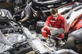 Old used car part warehouse worker checking inventory in garage. Staff worker working in recycle motor junkyard auto parts