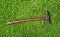 Old used hammer on the green grass