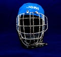 Old, used Jofa ice hockey protetcion helmet on blue background, focus on the grid.