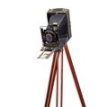 Old camera with bellows on wooden tripod on white background Royalty Free Stock Photo