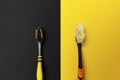 Old used and new toothbrushes on cotrast black and yellow backgrounds. The concept of the need for frequent toothbrush changes Royalty Free Stock Photo