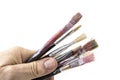 Old and used paint brushes with hand on white background. Royalty Free Stock Photo