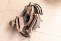 Old, used, rusty rear hub, inner part without brake disc, on the beige tiled floor of the workshop