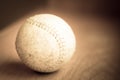 Old, used softball in sepia tones