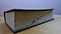 Old thick dictionary closeup with alphabetical order markings on a wooden table