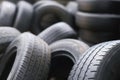 Old used tires stacked with high piles. close up damaged worn black tire tread car. Royalty Free Stock Photo