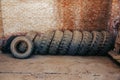 Old used truck tires stand against the wall in the garage