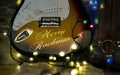 Old used vintage guitar with Christmas lights on a wooden plank