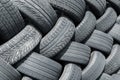 Old used weared car and truck wheels tyres pile stacked in rows stored for recycling. Heap of many rubber tires wall Royalty Free Stock Photo
