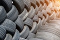 Old used weared car and truck wheels tyres pile stacked in rows stored for recycling. Heap of many rubber tires wall Royalty Free Stock Photo