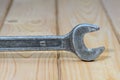 Old used wrench on a wooden background. Vintage spanner
