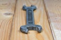 Old used wrench on a wooden background. Vintage spanner