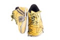 Old used  yellow worn out futsal sports shoes  on white background soccer sportware object isolated Royalty Free Stock Photo