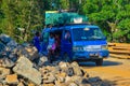 An old vehicle with a luggage on the roof, street view in Madagascar`s dirt road, people get out of public transport