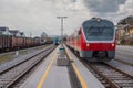 Old versus new passenger train standing on a platform. Concept of modernisation of rolling stock on railways