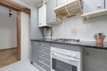 An old and very used kitchen with gray furniture and appliances