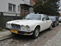 Old classic veteran ebony white Jaguar V12 Sovereign sedan executive parked