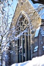 An old Victorian church in the snow on a sunny day.