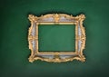 Old, victorian, gilded, decorative frame on a green wall,