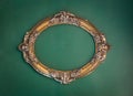 Old, victorian, gilded, decorative frame on a green wall, baroque