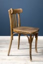 An old Viennese chair in a room against a dark blue wall and on a laminate Royalty Free Stock Photo