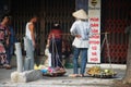 Old vietnam woman street vendors bearing hawker basket walking sale local food product to vietnamese people and foreign travelers Royalty Free Stock Photo