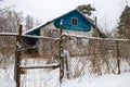 Old village house behind a fence on a winter day Royalty Free Stock Photo