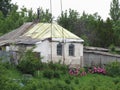 Old village house with a fence and a flower bed