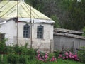 Old village house with a fence and a flower bed