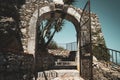 Old, vintage aged stone wall with arched opening gate and stairs up Royalty Free Stock Photo