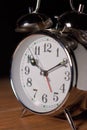 Old antique analog metalic alarm clock on a table