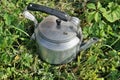 Old vintage aluminum electric kettle on a green rustic lawn Royalty Free Stock Photo