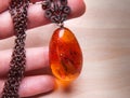 Old vintage amber pendant in female hand Royalty Free Stock Photo