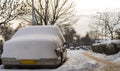 An old vintage American car under a heavy layer of snow .