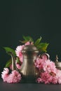 Old, vintage antique mocha coffee pot decorated with cherry blossom flowers, dark moody shot